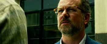 Movie still from “13 Hours” (2016), directed by Michael Bay – A person wearing glasses; Close Up shot, Low angle