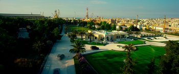 Movie still from “13 Hours” (2016), directed by Michael Bay – An aerial view of a city with a lot of trees and buildings; Extreme Wide shot, High angle