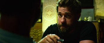 Movie still from “13 Hours” (2016), directed by Michael Bay – A man with a beard is holding a remote control; Close Up shot, Over the shoulder angle