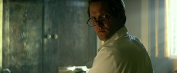 Movie still from “13 Hours” (2016), directed by Michael Bay – A person wearing a white shirt and glasses; Close Up shot, Low angle