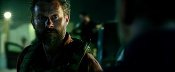 Movie still from “13 Hours” (2016), directed by Michael Bay – A person holding a violin; Close Up shot, Over the shoulder angle