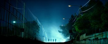 Movie still from “13 Hours” (2016), directed by Michael Bay – A group of people walking down a street at night; Extreme Wide shot, Low angle