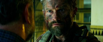 Movie still from “13 Hours” (2016), directed by Michael Bay – A person with a face covered in blood; Close Up shot, Low angle