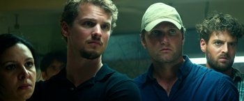 Movie still from “13 Hours” (2016), directed by Michael Bay – Two men standing next to each other in front of a wall; Close Up shot, Low angle