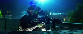 Movie still from “13 Hours” (2016), directed by Michael Bay – A man with a rifle and a night vision device; Medium shot, Over the shoulder angle