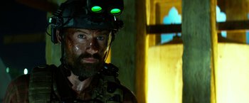 Movie still from “13 Hours” (2016), directed by Michael Bay – A person wearing a helmet; Close Up shot, Over the shoulder angle