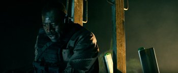 Movie still from “13 Hours” (2016), directed by Michael Bay – A man sitting on a bench at night; Close Up shot, Low angle