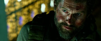 Movie still from “13 Hours” (2016), directed by Michael Bay – A person with a beard and face paint; Close Up shot, Over the shoulder angle