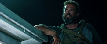 Movie still from “13 Hours” (2016), directed by Michael Bay – A man with a beard holding a sword; Close Up shot, Over the shoulder angle
