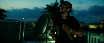 Movie still from “13 Hours” (2016), directed by Michael Bay – A man with a helmet on holding a camera; Medium shot, Low angle
