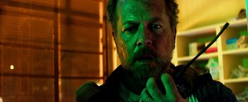 Movie still from “13 Hours” (2016), directed by Michael Bay – A person wearing a green shirt; Close Up shot, Low angle
