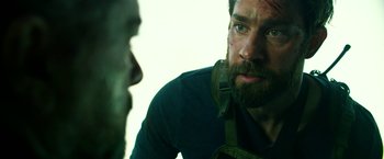 Movie still from “13 Hours” (2016), directed by Michael Bay – A man with a beard is looking at another man with a beard; Close Up shot, Over the shoulder angle