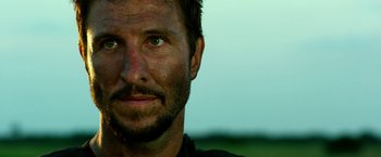 Movie still from “13 Hours” (2016), directed by Michael Bay – A person with dirt on his face; Close Up shot, Over the shoulder angle