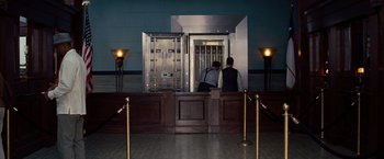 Movie still from “2 Guns” (2013), directed by Baltasar Kormákur – Two people standing in front of an open bank vault door; Wide shot, High angle