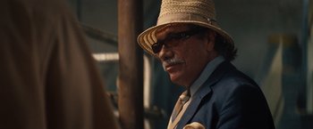 Movie still from “2 Guns” (2013), directed by Baltasar Kormákur – An older man wearing a straw hat and a suit; Close Up shot, Over the shoulder angle