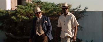 Movie still from “2 Guns” (2013), directed by Baltasar Kormákur – Two men in hats and suits walking on a path; Medium shot, Low angle
