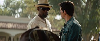 Movie still from “2 Guns” (2013), directed by Baltasar Kormákur – A man wearing a hat talking to another man; Close Up shot, Over the shoulder angle