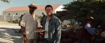 Movie still from “2 Guns” (2013), directed by Baltasar Kormákur – A man holding a plate of food next to another man; Medium shot, Over the shoulder angle