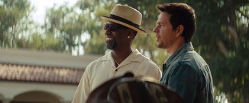 Movie still from “2 Guns” (2013), directed by Baltasar Kormákur – A man wearing a hat and sunglasses next to another man; Close Up shot, Over the shoulder angle