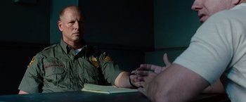 Movie still from “2 Guns” (2013), directed by Baltasar Kormákur – A man sitting in front of a table with a book; Close Up shot, Over the shoulder angle