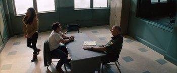 Movie still from “2 Guns” (2013), directed by Baltasar Kormákur – Two men sitting at a table in an interrogation room; Wide shot, Over the shoulder angle