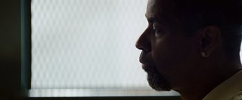 Movie still from “2 Guns” (2013), directed by Baltasar Kormákur – A person's face with a window in the background; Close Up shot, Low angle