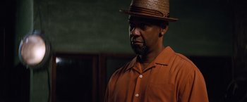 Movie still from “2 Guns” (2013), directed by Baltasar Kormákur – A man wearing a brown shirt and a brown hat; Close Up shot, Over the shoulder angle