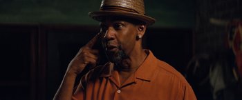 Movie still from “2 Guns” (2013), directed by Baltasar Kormákur – A man with a beard wearing an orange shirt and a brown hat; Close Up shot, Low angle