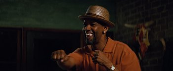 Movie still from “2 Guns” (2013), directed by Baltasar Kormákur – A man wearing an orange shirt and a brown hat; Close Up shot, Low angle