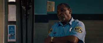 Movie still from “2 Guns” (2013), directed by Baltasar Kormákur – A man in a blue shirt is standing in front of a wall; Close Up shot, Low angle