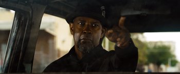 Movie still from “2 Guns” (2013), directed by Baltasar Kormákur – A person wearing a hat and holding an umbrella; Close Up shot, Over the shoulder angle