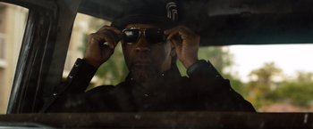 Movie still from “2 Guns” (2013), directed by Baltasar Kormákur – A man putting on sunglasses while sitting in a car; Close Up shot, Over the shoulder angle