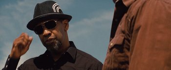 Movie still from “2 Guns” (2013), directed by Baltasar Kormákur – A man wearing a hat and sunglasses talking to another man; Close Up shot, Over the shoulder angle