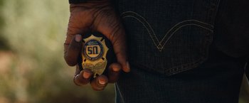 Movie still from “2 Guns” (2013), directed by Baltasar Kormákur – A person holding a badge in their hands; Extreme Close Up shot, Overhead angle