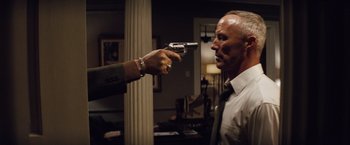 Movie still from “2 Guns” (2013), directed by Baltasar Kormákur – A man holding a gun pointed at another man's face; Medium shot, Low angle
