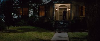 Movie still from “2 Guns” (2013), directed by Baltasar Kormákur – A man standing at the door of a house at night; Extreme Wide shot, High angle