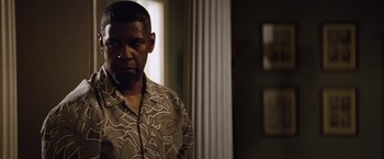 Movie still from “2 Guns” (2013), directed by Baltasar Kormákur – A person standing in front of a window; Medium shot, Over the shoulder angle