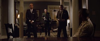 Movie still from “2 Guns” (2013), directed by Baltasar Kormákur – A group of men standing in a living room holding nintendo wii controllers; Wide shot, Low angle