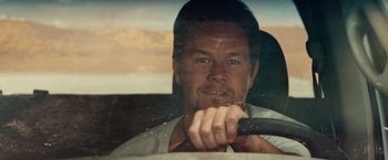 Movie still from “2 Guns” (2013), directed by Baltasar Kormákur – A person in a car holding a steering wheel; Close Up shot, Over the shoulder angle