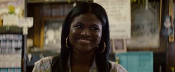 Movie still from “2 Guns” (2013), directed by Baltasar Kormákur – A woman with long black hair smiles for the camera; Close Up shot, Over the shoulder angle