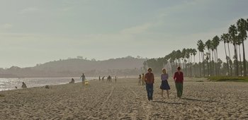 Movie still from “20th Century Women” (2016), directed by Mike Mills – A group of people walking on a beach near the water; Extreme Wide shot, High angle