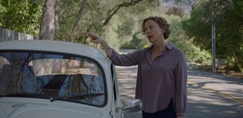 Movie still from “20th Century Women” (2016), directed by Mike Mills – A woman standing next to an old white car on the side of the road; Medium shot, Over the shoulder angle