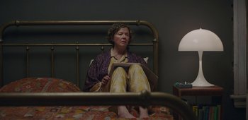 Movie still from “20th Century Women” (2016), directed by Mike Mills – A woman sitting on a bed reading a book; Medium shot, High angle
