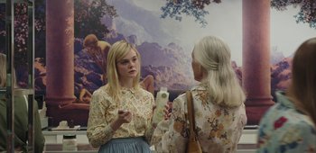 Movie still from “20th Century Women” (2016), directed by Mike Mills – Two women standing in front of a painting talking to each other; Medium shot, Over the shoulder angle