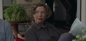 Movie still from “20th Century Women” (2016), directed by Mike Mills – An older woman sitting in a chair in front of a clock; Close Up shot, Over the shoulder angle