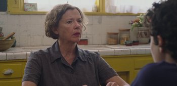 Movie still from “20th Century Women” (2016), directed by Mike Mills – An older woman sitting at a table in front of a sink; Close Up shot, Over the shoulder angle