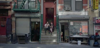 Movie still from “20th Century Women” (2016), directed by Mike Mills – Two people sitting on the steps of an apartment building; Wide shot, High angle