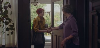 Movie still from “20th Century Women” (2016), directed by Mike Mills – Two women shaking hands in front of a door; Medium shot, Over the shoulder angle