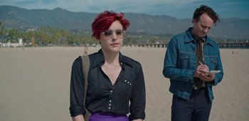 Movie still from “20th Century Women” (2016), directed by Mike Mills – A woman with red hair wearing sunglasses and a black shirt; Medium shot, Over the shoulder angle