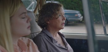 Movie still from “20th Century Women” (2016), directed by Mike Mills – An older woman sitting in the back seat of a car; Close Up shot, Over the shoulder angle